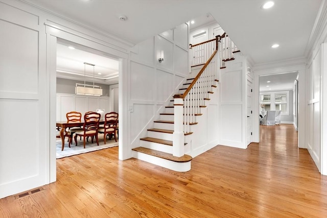 1 Apollo Cir, Lexington, MA 02421 - staircase featuring a decorative wall, ornamental molding, wood finished floors, and recessed lighting