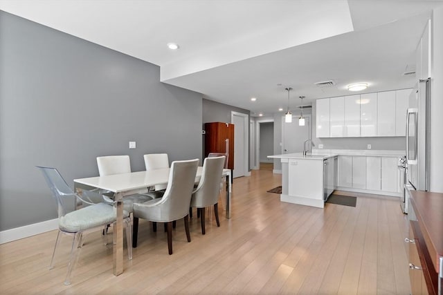 dining space featuring sink and light wood-type flooring