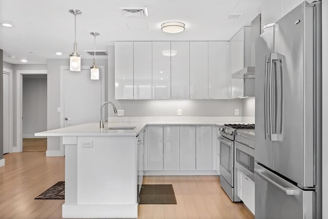 kitchen featuring white cabinetry, sink, stainless steel appliances, and hanging light fixtures