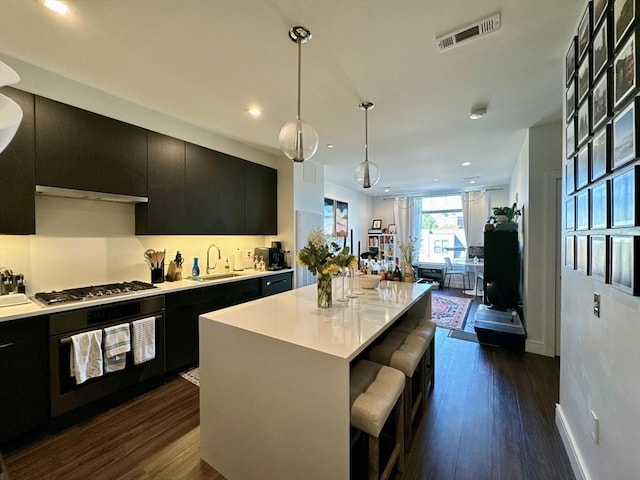 99 Sumner St Unit 305, Boston, MA 02128 - kitchen with black oven, dark cabinetry, stainless steel gas cooktop, a sink, and dark wood-type flooring