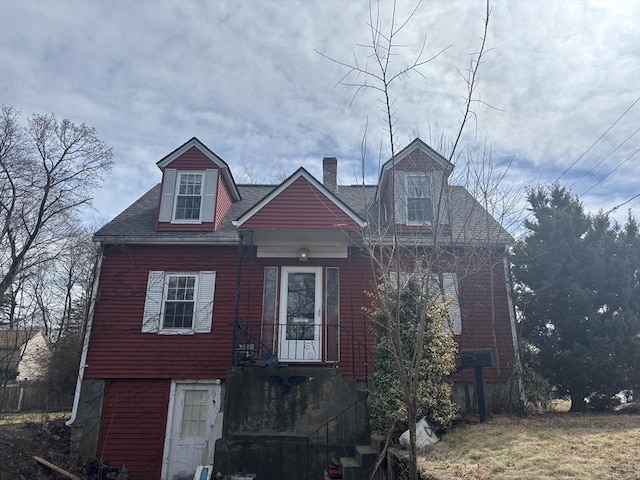 view of front of property with roof with shingles and a chimney