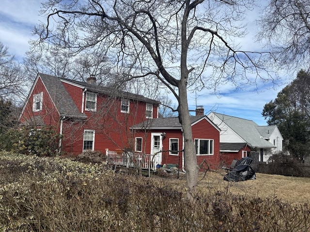 view of front of property with a chimney and a shingled roof