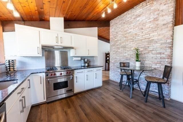 kitchen with high end stove, under cabinet range hood, wood ceiling, white cabinets, and dark wood finished floors