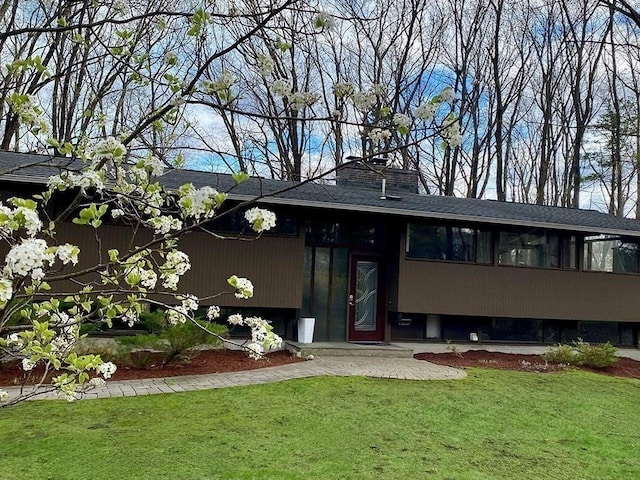 back of property with a lawn