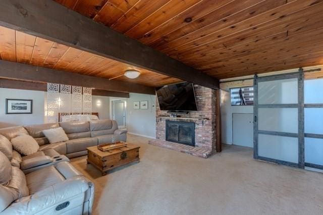 living room featuring beam ceiling, wooden ceiling, carpet floors, and a fireplace