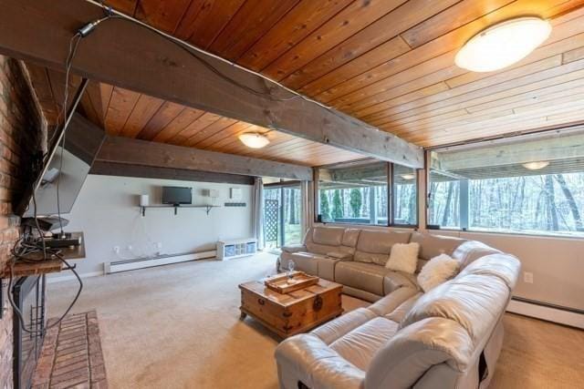 carpeted living room with a wealth of natural light, wooden ceiling, and a baseboard heating unit