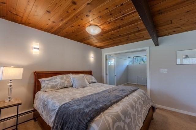 bedroom with wood ceiling, baseboards, and a baseboard radiator