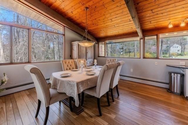 dining area with a baseboard heating unit, vaulted ceiling with beams, hardwood / wood-style flooring, and wood ceiling