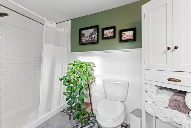 bathroom featuring tile patterned flooring, toilet, wood walls, and curtained shower