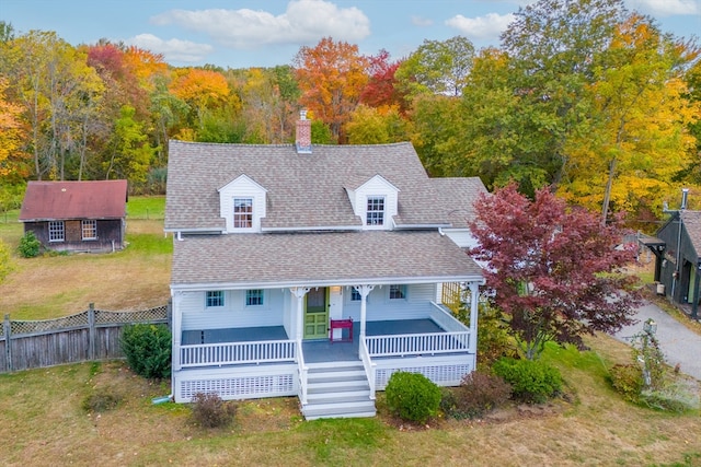 view of front of property featuring a porch, a front lawn, and an outdoor structure