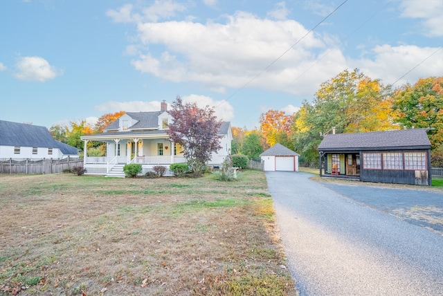 view of front of house with covered porch, an outbuilding, and a garage