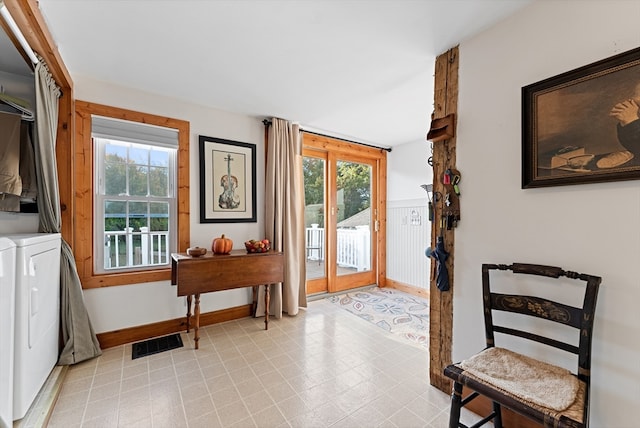 doorway to outside featuring stacked washer and clothes dryer and a wealth of natural light