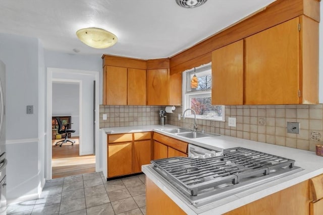 kitchen with kitchen peninsula, stainless steel appliances, tasteful backsplash, and sink