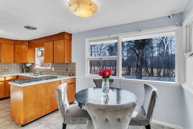 kitchen featuring light tile patterned floors, decorative backsplash, and sink