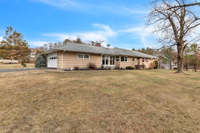 back of property with a garage and a yard