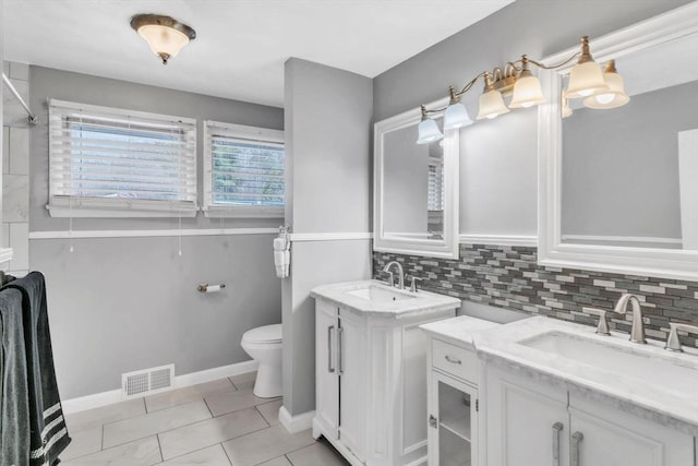 bathroom featuring tasteful backsplash, vanity, tile patterned floors, and toilet