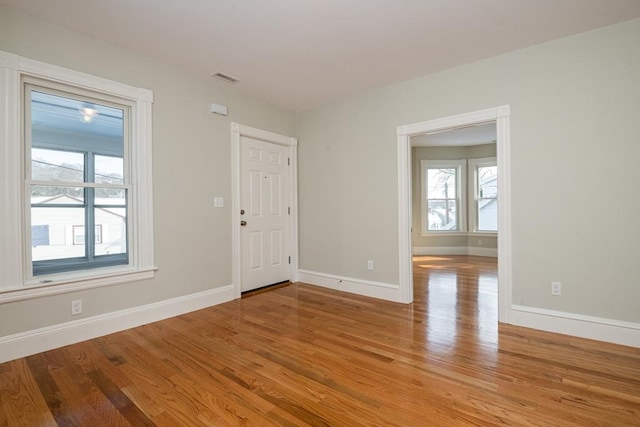 empty room with a wealth of natural light and light wood-type flooring