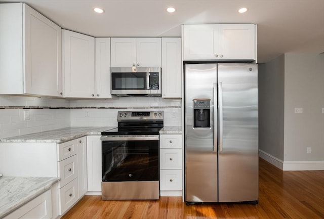 kitchen featuring white cabinetry, appliances with stainless steel finishes, and light hardwood / wood-style floors