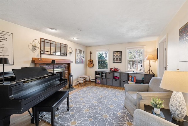 living area featuring a fireplace, wood finished floors, and a baseboard radiator