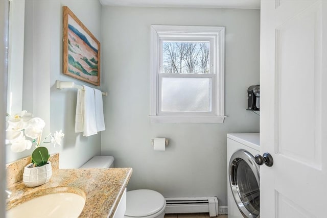 half bath with vanity, washer / dryer, toilet, and baseboard heating