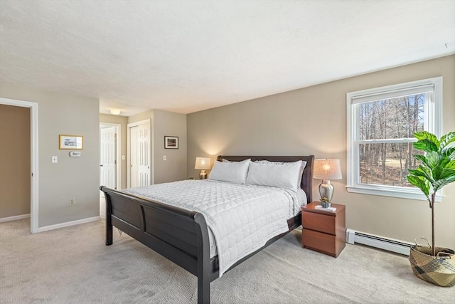 bedroom with baseboards, light carpet, baseboard heating, and a closet