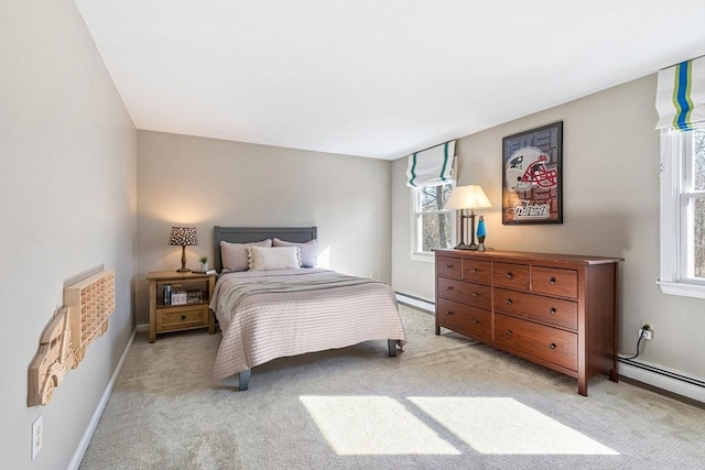 bedroom with baseboard heating, light colored carpet, and baseboards