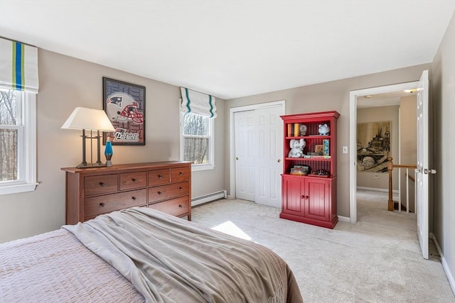 bedroom featuring a closet, a baseboard heating unit, baseboards, and carpet floors