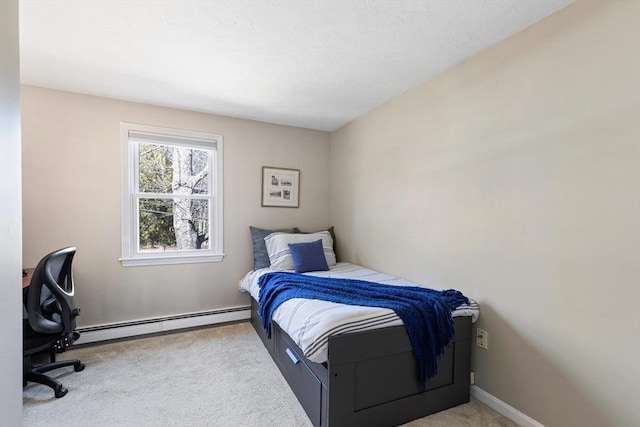 carpeted bedroom featuring baseboard heating and baseboards