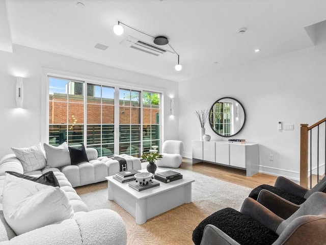 living area featuring baseboards and light wood-style flooring