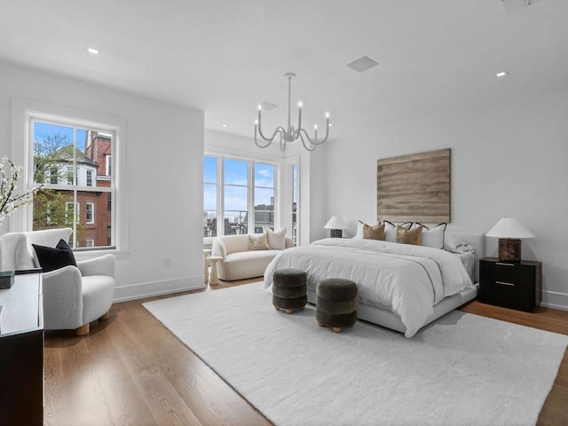 bedroom with a chandelier, baseboards, wood finished floors, and recessed lighting