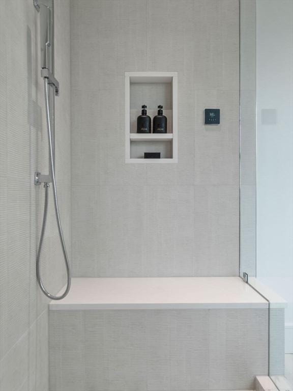 bathroom featuring tiled shower and tiled bath