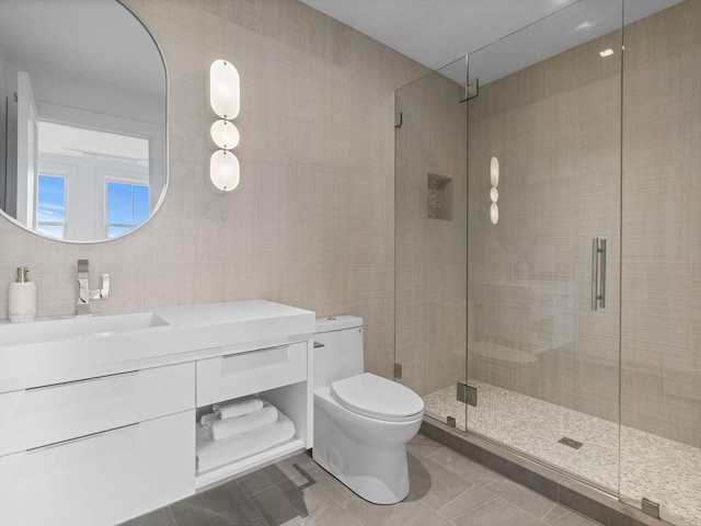 full bathroom with tile patterned flooring, toilet, a stall shower, vanity, and tile walls