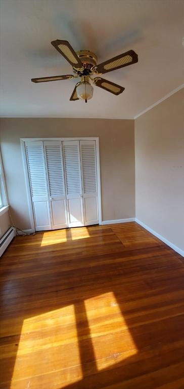58 Jay St, North Attleboro, MA 02760 - spare room with wood finished floors, ceiling fan, baseboards, and a baseboard heating unit