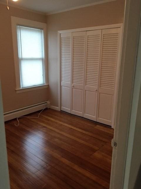 58 Jay St, North Attleboro, MA 02760 - unfurnished bedroom with baseboard heating, ornamental molding, dark wood-type flooring, a closet, and baseboards