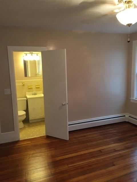 58 Jay St, North Attleboro, MA 02760 - empty room with wood-type flooring, a ceiling fan, a sink, and a baseboard radiator