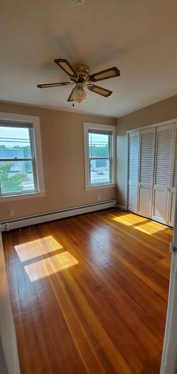 58 Jay St, North Attleboro, MA 02760 - unfurnished room featuring wood finished floors, a baseboard radiator, and a ceiling fan