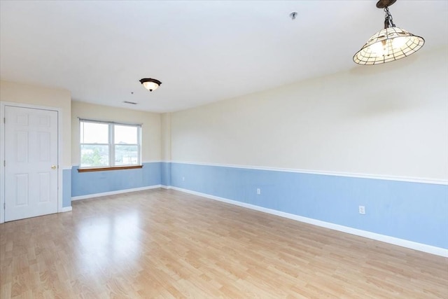 unfurnished room featuring light wood finished floors and baseboards