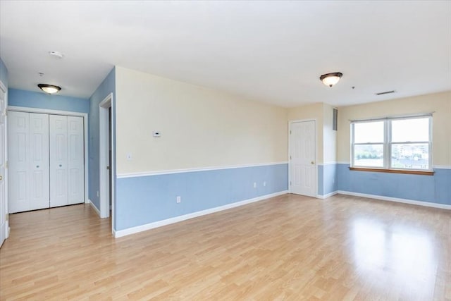 empty room featuring light wood-style flooring and baseboards