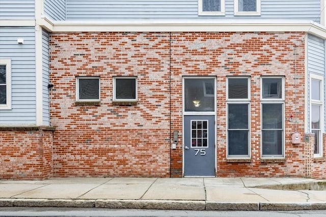 doorway to property featuring brick siding