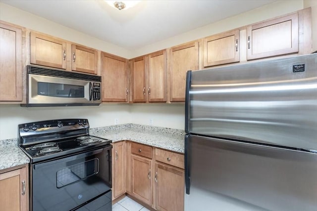 kitchen featuring appliances with stainless steel finishes, light stone countertops, and light tile patterned floors