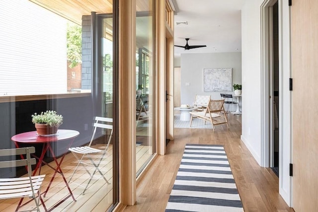 doorway to outside with ceiling fan and light wood-type flooring