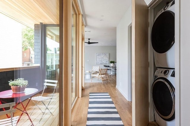 washroom featuring light hardwood / wood-style floors, stacked washer / dryer, and ceiling fan