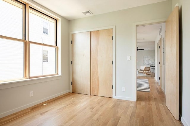 unfurnished bedroom featuring a closet and light hardwood / wood-style floors