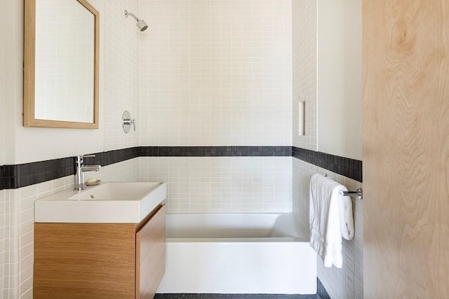 bathroom featuring vanity and tile walls