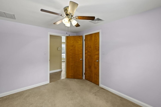 spare room featuring visible vents, ceiling fan, light carpet, and baseboards