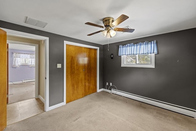 unfurnished bedroom with light carpet, baseboards, visible vents, and baseboard heating