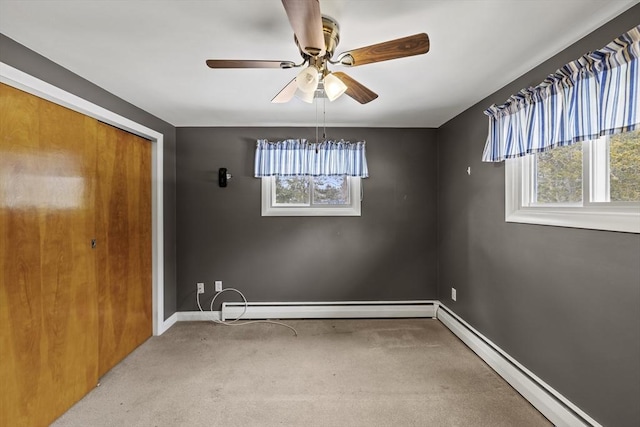 unfurnished room with light carpet, a healthy amount of sunlight, and a baseboard heating unit