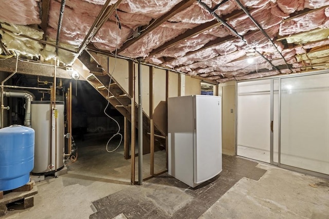 unfinished basement with gas water heater and freestanding refrigerator