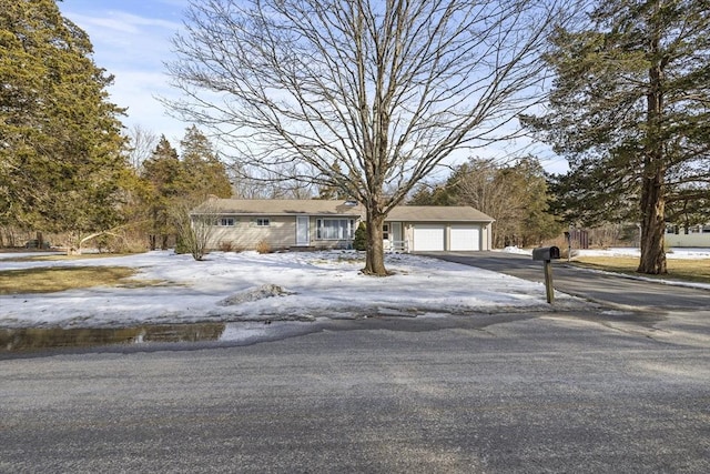 view of front of property featuring an attached garage and aphalt driveway