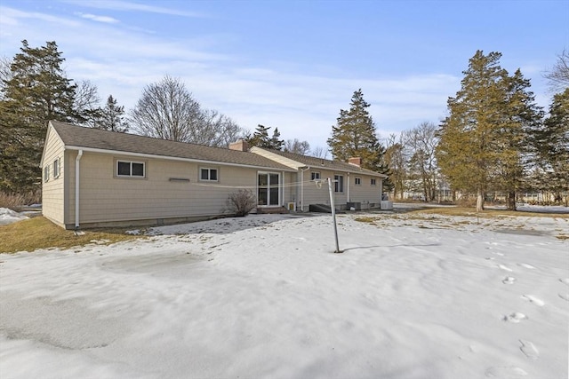 view of snow covered rear of property